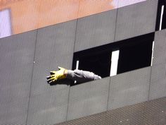 a gloved hand sticking out of the window of a building