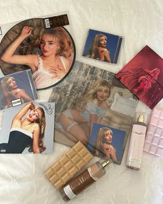 various beauty products are laid out on a white sheet with pictures and photos behind them