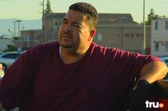 a man sitting in the back of a pick up truck looking off into the distance