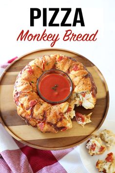 pizza monkey bread on a wooden plate with sauce in the middle and other food items around it