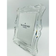 a clear glass photo frame with a pencil in it's center and waterfond logo on the front