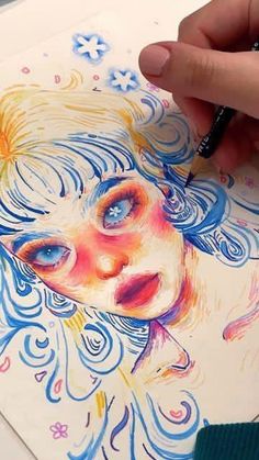 a person is drawing with colored pencils on paper