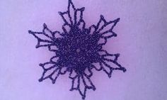 a close up of a purple object on a white surface with small dots in the middle