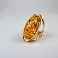 Amber ring. Brown Orange Baltic Amber gemstone ring. Certificated gold plalted Sterling silver 925 with stamps - hallmarks. Big nice stunning ring. Adjustable size. Very big and stunning amber gemstone ring. weight 11.29 gr GOLD plated ring. Stone size- 4.7 x 2 cm This item was made of natural Baltic Amber. All the amber used in my jewelry is collected in my home country Lithuania. I sell only genuine, real, not pressed, authentic, natural Baltic Amber. Item may have natural imperfections. Amber Wedding Rings With Polished Finish, Amber Hallmarked Rings In Fine Jewelry Style, Amber Open Ring For Anniversary, Gift Yellow Gold Oval Cabochon Rings, Elegant Gold Oval Cabochon Ring, Luxury Amber Rings As Gifts, Luxury Amber Rings For Formal Occasions, Gold Dome Ring With Cabochon For Formal Events, Gold Dome Ring With Gemstone For Formal Events