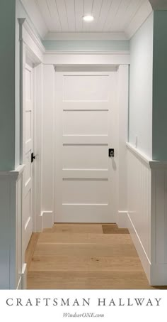 an empty hallway with white walls and wood flooring on the bottom level is seen in this photograph