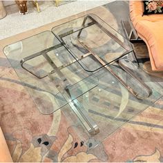 a glass coffee table with metal legs on carpeted flooring in living room area