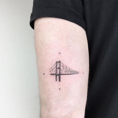 a black and white photo of a bridge tattoo on the arm