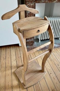 a wooden chair sitting on top of a hard wood floor next to a radiator