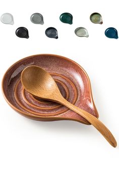 a wooden spoon sitting on top of a bowl filled with different colored bowls and spoons