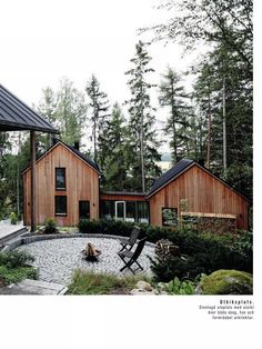 a couple of wooden buildings sitting in the middle of a forest next to a pond