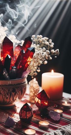 a bowl filled with crystals sitting on top of a table next to candles and flowers