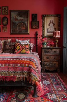 a bedroom with red walls and pictures on the wall