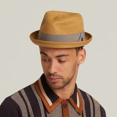 This unlined hat exudes effortless style and sophistication with its minimalist design and quality craftsmanship. Adorned with a 15mm square brown metal badge, it boasts an air of authenticity and refined detail. The grosgrain band adds a touch of elegance to the overall aesthetic, complementing the hat's clean lines. With a 1-inch skimpy turned-up brim, this hat offers a subtle yet stylish look, perfect for sunny days.  Its tear drop crown design adds a classic touch, enhancing its timeless app Fitted Beige Fedora With Flat Brim, Beige Flat Brim Fedora, Modern Panama Hat With Short Brim For Spring, Modern Fedora With Short Brim For Everyday, Modern Beach Hats For Spring, Modern Fedora Panama Hat For Spring, Summer Panama Hat With Short Brim For Everyday Use, Modern Fitted Fedora With Flat Brim, Modern Flat Brim Fedora For Spring