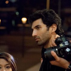 a man holding a camera next to a woman