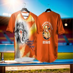 two t - shirts are sitting on a bench in front of an empty soccer field