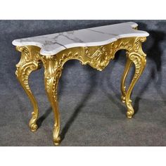 a gold and white marble topped console table