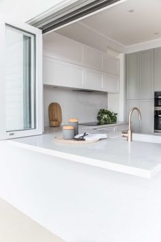 an open kitchen with white cabinets and stainless steel appliances