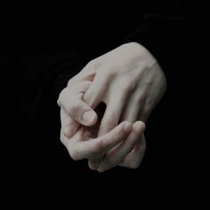 two hands holding each other in the dark