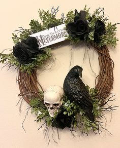 a wreath decorated with fake skulls and black roses is hanging on the wall next to a skull