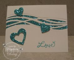 a card with two hearts on it and the word love is written in blue glitter