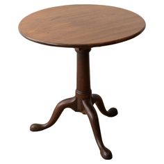 a small wooden table with two legs and a round top on an isolated white background