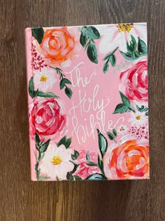 a pink notebook with flowers painted on it