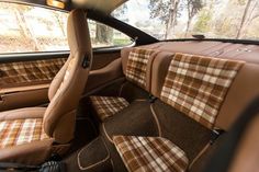 the interior of a car with brown and tan plaid upholstered seats on it