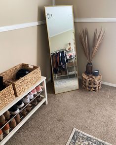 a room with a mirror, shoes and baskets on the floor