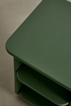 a green side table with three shelves on each end and one shelf below the top