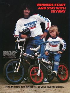 two young boys sitting on their bikes in front of an advertisement for the new york giants