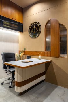 an office with a desk and chairs in front of a clock on the wall above it