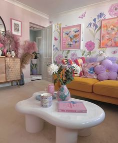 a living room filled with furniture and flowers on top of a coffee table in front of a mirror