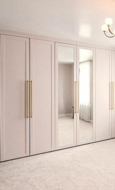 an empty room with mirrored closet doors and chandelier