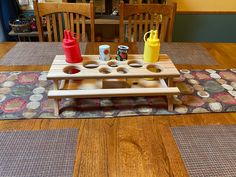 a wooden table topped with cups and trays on top of a carpeted floor