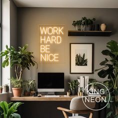 a desk with a computer and some plants on it