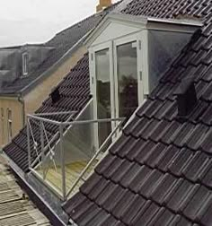 the roof of a building with a glass door on it's side and an open window in the middle