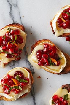 small crostini with cream cheese, pomegranate and herbs on top