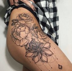 a woman's thigh with flowers and dots on the side, in black and white