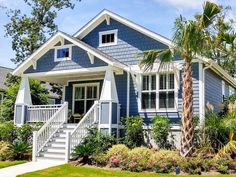 a blue house with white trim and palm trees