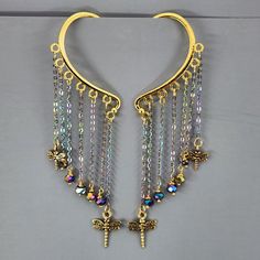 a pair of gold toned earrings with multicolored beads and cross charms hanging from them