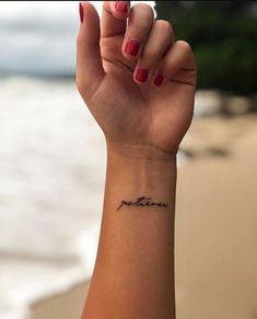 a woman's arm with a small tattoo on the wrist that reads, mother