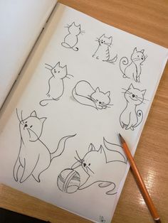 an open notebook with drawings of cats on it and a pencil resting next to it