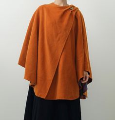 Vintage 1970s Burnt Orange Wool Cape with Plaid Lining This striking burnt orange cape is estimated to be from the 1970s, a decade known for bold, expressive fashion. Made from what feels like a wool blend, it features a single-button closure at the shoulder and a stunning plaid lining for added warmth and style. The wide, flowing silhouette makes it ideal for layering over dresses or tailored separates. Styling Tips:  Pair with tall boots and a midi dress for an autumn-ready look, or style with Wool Cape, Scarf Design, Tall Boots, Sustainable Clothing, Buy Vintage, Burnt Orange, Mode Vintage, Cape, Wool Blend