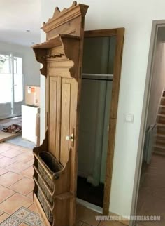 a tall wooden cabinet sitting in the corner of a room with tile flooring and walls