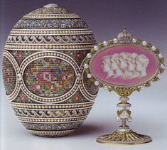 an ornately decorated urn next to a glass vase