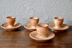 three cups and saucers sitting on top of a wooden table next to each other