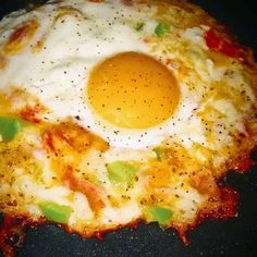 an egg on top of some sort of pizza with cheese and seasoning sprinkles