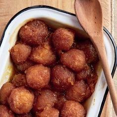 a bowl filled with fried food next to a wooden spoon