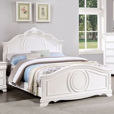 a white bed sitting in a bedroom next to a dresser and mirror on top of a hard wood floor