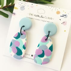 two pairs of colorful earrings sitting on top of a card